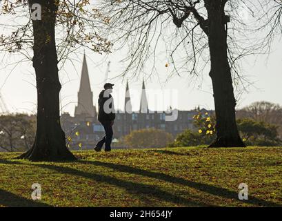 Inverleith Park, Édimbourg, Écosse, Royaume-Uni.13 novembre.Soleil pour les personnes de tous âges prenant l'exercice avec la température de 11 degrés centigrade.Un parc populaire où de nombreux arbres à feuilles caduques ont perdu leurs feuilles d'automne à cause du vent récent et de fortes pluies.Photo : exercice avec les flèches silhouetées de la cathédrale St Mary en arrière-plan de la capitale écossaise de l'ouest. Crédit : Arch White/Alamy Live News. Banque D'Images