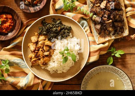 Poulet se'i. Plat de poulet fumé de Nusa Tenggara Timur, servi avec du riz et des feuilles de manioc Banque D'Images