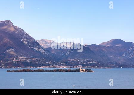 L'Isola del Garda boisée (Borghese Cavazza) et sa villa se trouvent en contrebas de montagnes escarpées près de San Felice del Benaco, Lombardie, Italie. Banque D'Images