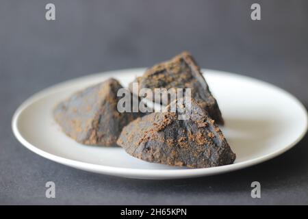 Morceaux de palmier coupés en jaggery.La palmeraie est un édulcorant nutritif extrait à l'aide des techniques traditionnelles d'ébullition du jus de palmier.Prise de vue sur un fond noir Banque D'Images