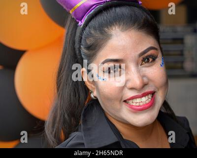 Jeune femme yucatecenne mexicaine gaie avec maquillage traditionnel et bijoux de visage/gemmes scintillants souriants le jour des morts (Día de los Muerto). Banque D'Images