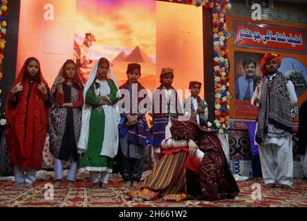 Les élèves présentent un tableau sur scène lors d'une cérémonie à l'occasion de la célébration de la semaine de reconnaissance du Shah Abdul Latif Bhittai, qui s'est tenue au Musée Sindh à Hyderabad le samedi 13 novembre 2021. Banque D'Images