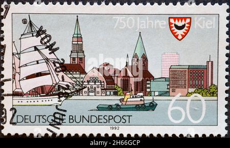 ALLEMAGNE - VERS 1992 : timbre-poste de l'Allemagne, montrant les armes de la ville et la vue sur le port avec la ville de Kiel.Occasion: 750 ans de Kiel Banque D'Images