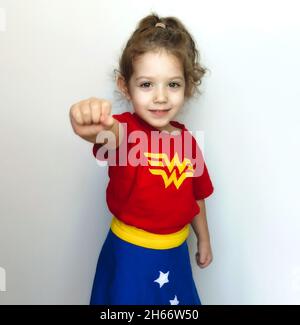 Portrait d'une jeune fille mignonne posant comme un super héros avec le costume de femme émerveillement Banque D'Images