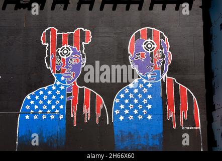 Détail d'une fresque de projet de noir inachevé par Cadex Herrera avec deux jeunes avec des cibles de vue de canon sur leur front illustrant TH Banque D'Images