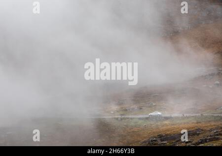 Healy Pass, Cork, Irlande.13 novembre 2021.Une voiture descend lentement sur l'étroite route de montagne tandis que le brouillard et la brume descendent sur le col Healy, Co. Cork, Irlande.- photo; David Creedon / Alamy Live News Banque D'Images