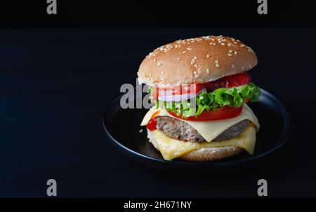 hamburger frais et savoureux isolé sur fond noir Banque D'Images