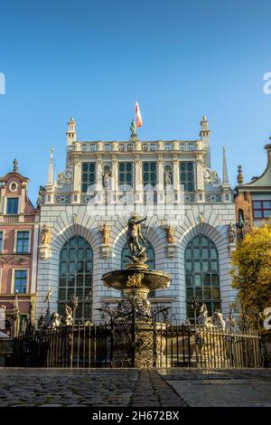 GDANSK, POLOGNE - 08 octobre 2021 : la fontaine de Neptune devant le bâtiment Artus court avec drapeau de la ville au sommet de Gdansk, Pologne Banque D'Images