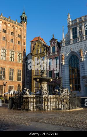 GDANSK, POLOGNE - 08 octobre 2021 : la fontaine de Neptune devant le bâtiment Artus court avec drapeau de la ville au sommet de Gdansk, Pologne Banque D'Images