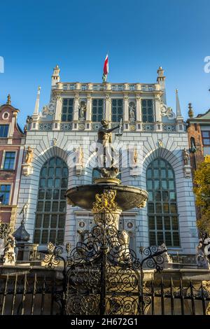 GDANSK, POLOGNE - 08 octobre 2021 : la fontaine de Neptune devant le bâtiment Artus court avec drapeau de la ville au sommet de Gdansk, Pologne Banque D'Images