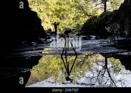 Silhouette de photographe à l'œuvre dans la grotte de Rydal, dans le Lake District, en Angleterre Banque D'Images