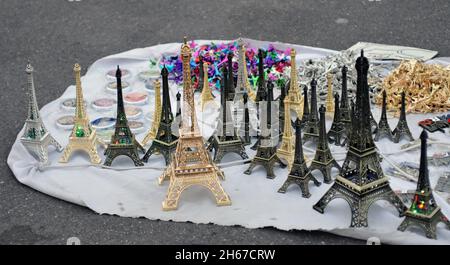 Des répliques miniatures de la Tour Eiffel et d'autres souvenirs sont présentés à la vente par un vendeur de rue à Paris. Banque D'Images