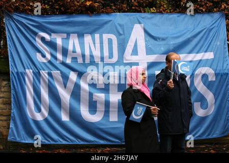 Deux manifestants, portant le drapeau de solidarité Stand4UYhurs, se tiennent à côté d'une bannière pendant la manifestation.des manifestants à Manchester se sont rassemblés devant le consulat chinois de la ville sur Denison Road, pour manifester contre le traitement odieux de la population ouïghoure par la Chine dans ce pays.Près de 200 manifestants, nombreux sont ceux de la communauté musulmane de Manchester qui ont organisé une manifestation très bruyante et très vocale aux portes principales du consulat, et cette partie de la route a été enraillée, sous la surveillance de la police du Grand Manchester à distance. Banque D'Images