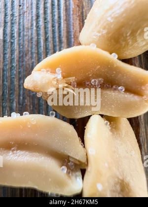 Gros plan d'arachides frites pelées et salées sur une planche de bois Banque D'Images