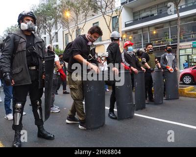 Manifestants avec boucliers faits maison lorsque des centaines de manifestants sont descendus dans les rues de Lima dans le cadre des activités commémorant un an depuis la mort d'Inti Sotelo et Bryan Pintado, deux jeunes militants péruviens tués lors des manifestations du 14 novembre 2020,Ce qui a forcé le président du Pérou de l'époque, Manuel Merino, à démissionner 5 jours seulement après son entrée en fonction.Merino a été nommé président par le congrès après avoir destitué Martin Vizcarra, qui à son tour a remplacé Pedro Pablo Kuczynski, également congédié par le congrès. Banque D'Images