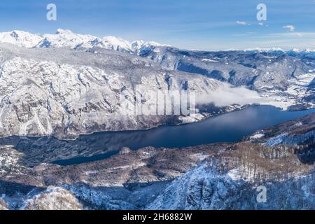 Vue sur le lac de Bohinj et les montagnes environnantes en hiver Banque D'Images