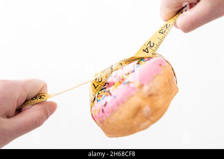 Gros plan sur le Donut et le ruban de mesure, la perte de poids et le concept de régime. Banque D'Images