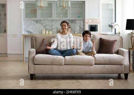 Bonne maman indienne et petit fils enfant assis sur le canapé Banque D'Images