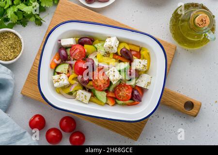 Salade Horiatiki de cuisine grecque faite avec des morceaux de tomates, concombres, oignons, feta, olives et assaisonnées de sel, poivre, origan et olive Banque D'Images