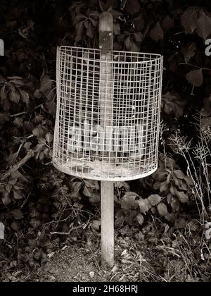 Photo verticale d'un vieux trashcan en fer à l'extérieur en niveaux de gris Banque D'Images