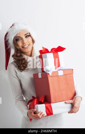 Femme en chapeau de Santa et présente, fond blanc, joyeux noël joyeuses fêtes Banque D'Images