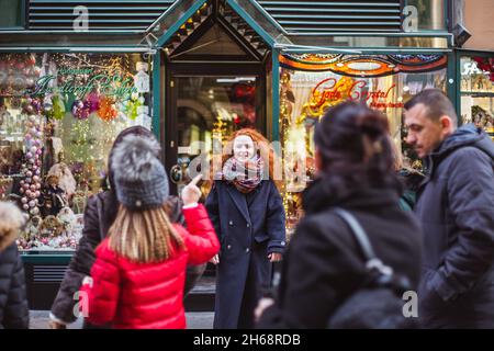 BUDAPEST, HONGRIE - 08 NOVEMBRE 2019: Fille de cheveux rouges appréciant le marché européen de Noël avec la foule de gens sur fond.Lumières floues et colorées Banque D'Images