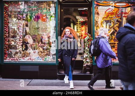 BUDAPEST, HONGRIE - 08 NOVEMBRE 2019: Fille de cheveux rouges appréciant le marché européen de Noël avec la foule de gens sur fond.Lumières floues et colorées Banque D'Images