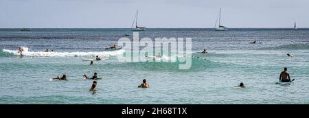 Honolulu, Hawaii - 6 novembre 2021 - les jeunes garçons jouent sur leurs planches de surf. Banque D'Images