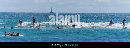 Honolulu, Hawaii - 6 novembre 2021 - les jeunes garçons jouent sur leurs planches de surf. Banque D'Images