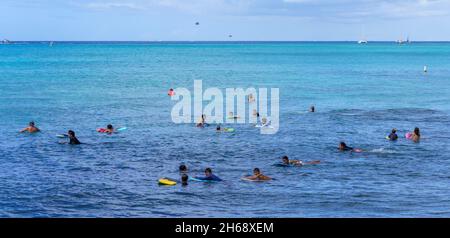 Honolulu, Hawaii - 6 novembre 2021 - les jeunes attendent avec leurs planches de surf pour la prochaine vague de surf. Banque D'Images