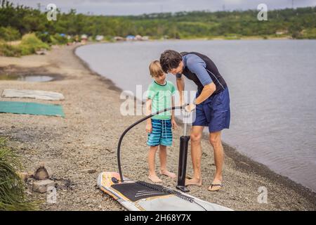 Le sportif gonfle le paddle Board, un divertissement moderne et à la mode Banque D'Images