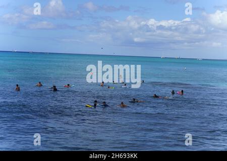 Honolulu, Hawaii - 6 novembre 2021 - les jeunes attendent avec leurs planches de surf pour la prochaine vague de surf. Banque D'Images