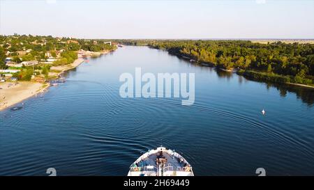 Cargo se tenant à la plage.Vidéo.Vue de dessus du magnifique vieux cargo sur la rivière.Le cargo se tient à la plage avec des gens en arrière-plan du village Banque D'Images