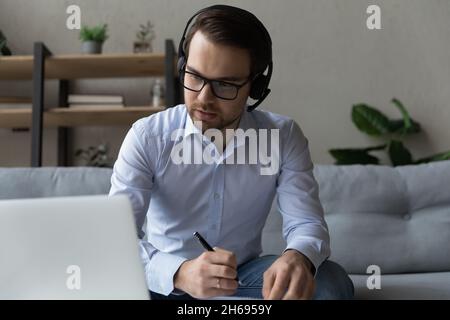 Un jeune homme d'affaires concentré organise des négociations par appel vidéo. Banque D'Images