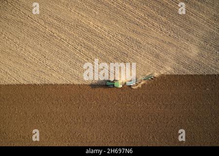 Agriculteur avec semis par tracteur - semis de récoltes dans les champs agricoles au printemps. Banque D'Images