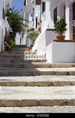 Magnifique village de Frigiliana, sud de l'Espagne Vieux quartier de Morisco vue d'une ruelle étroite avec maisons de ville et fleurs vue verticale Banque D'Images