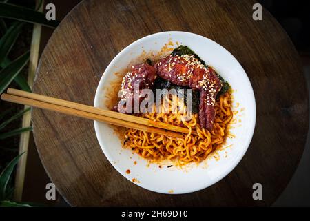 Poulet frit épicé chaud coréen servi avec des nouilles ramen instantanées, nouilles sautées. Banque D'Images