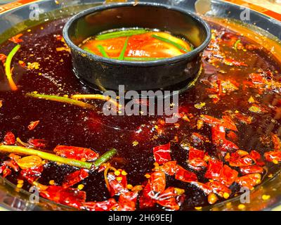 Piments rouges épicés et chauds nageant dans le célèbre pichet du Sichuan Banque D'Images