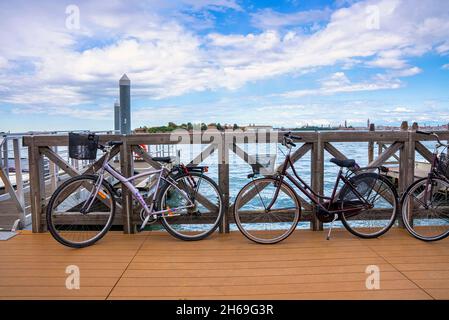 Vélos garés sur un pont en bois au-dessus du paysage marin Banque D'Images