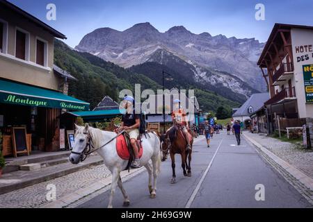 Les touristes voyagent à cheval à Gavarnie, dans le parc national des Pyrénées françaises, un site classé au patrimoine mondial de l'UNESCO. Banque D'Images