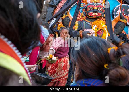 Katmandou, Népal - novembre 2021: Les pèlerins font des offrandes devant la figure de Kala Bhairab sur la place Durbar le 13 novembre 2021 à Katmandou, Banque D'Images