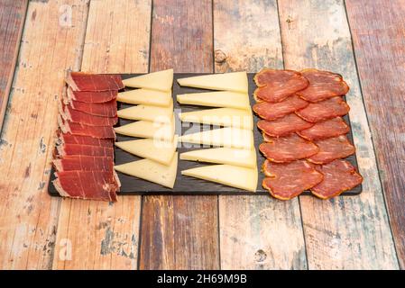 Populaire tapa espagnol de la planche à fromage Manchego et saucisses ibériques sur une table en bois Banque D'Images