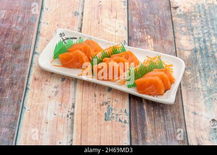 Le sashimi est un plat japonais qui se compose principalement de fruits de mer crus ou de poisson, finement coupés, mais pas autant qu'un carpaccio.Servi avec une sauce et Banque D'Images