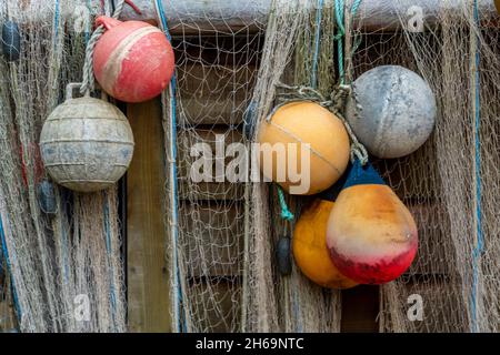 flotteurs de pêche colorés et filets de pêche accrochés au sec sur le côté d'une ancienne huttes de plage en bois à la crique de steephill près de ventnor sur l'île de wight. Banque D'Images