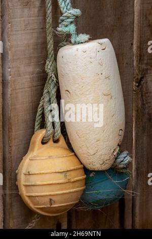 vieux chalutier de pêche jeté flotte et bouées accrochées sur le côté d'une cabane de plage sur l'île de wight comme décoration. flotsam et jetsam, bouée de pêche Banque D'Images