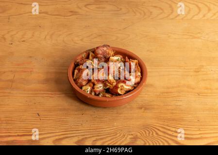 Tapa espagnole populaire de l'oreille de porc mariné grillée dans un pot en argile Banque D'Images