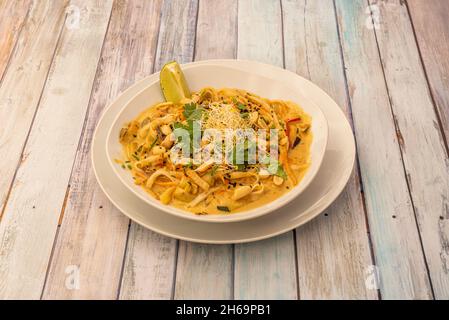 Tampon thaï, nouilles de riz, sauce de poisson, pâte de tamarin, poivron rouge,pousses de haricots, crevettes, poulet aux arachides et à la coriandre hachées, coin de citron, banane Banque D'Images