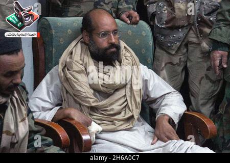 Une photo mise à disposition par le Centre des médias de Zintan montre le fils de l'ancien dirigeant libyen Saif Al Islam Kadhafi, arrêté, parlant avec les rebelles, à Zintan, en Libye, le 21 novembre 2011.Plus tôt, dans une vidéo, Saif Al Islam expliquait que les blessures sur ses doigts de droite avaient un mois, après un raid de l'OTAN sur son convoi.Photo de Balkis Press/ABACAPRESS.COM Banque D'Images