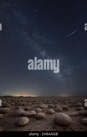 Une étoile tombant la nuit sur un terrain désertique de calcaires Banque D'Images