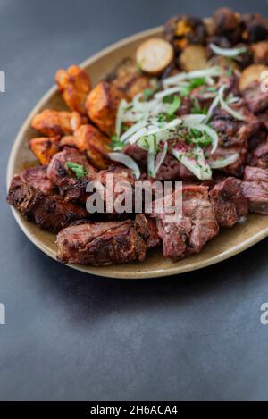 morceaux de viande barbecue kebabs porc grillé et bœuf et poulet sur une assiette avec oignons dans un restaurant Banque D'Images
